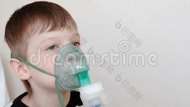 使用<strong>雾化</strong>器和吸入器进行治疗。 男孩通过吸入器面罩吸入。 前景。